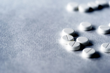 Obraz na płótnie Canvas White pills tablets on a gray surface close up
