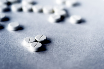 White pills tablets on a gray surface close up