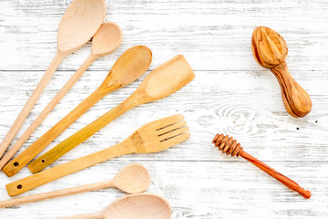 Fork, spoon in woodenware set on light wooden background top view