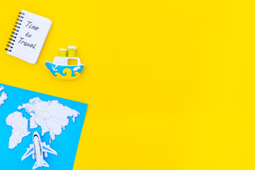 Time to travel. Accessories for treveling with children, map and toys on yellow background top view mock-up