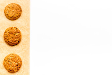 Cook homemade cookies. Pattern with fresh cookies on baking paper on white background top view copy space