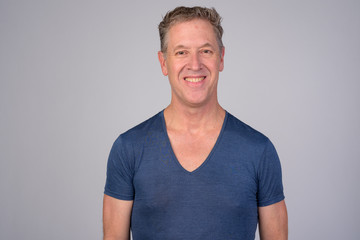 Obraz premium Happy mature man smiling against white background