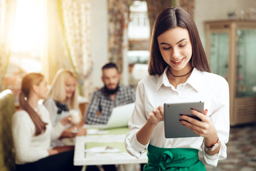 Portrait smiling young waitress standing in cafe