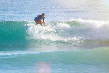 man in the ocean on a surfboard rides on top of a wave