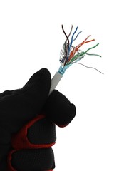 End of twisted pair of STP Cat.5E LAN network cable held between thumb and other fingers of hand in glack glove, white background. 