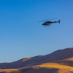 Fototapeta na wymiar Helicopter hovers over canyon in Utah Valley