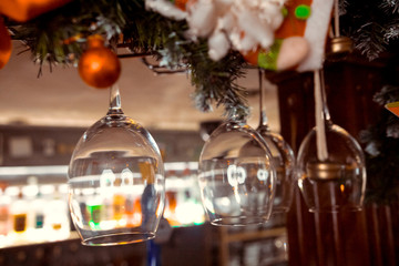 Glasses of wine. Glasses hanging above the bar in the restaurant. Empty glasses for wine. Wine and martini glasses in shelf above a bar rack in restaurant. blue lights, blue background, night life