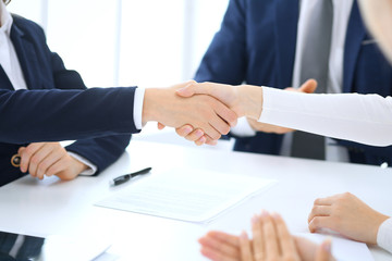 Group of business people or lawyers shaking hands finishing up a meeting , close-up. Success at negotiation and handshake concepts