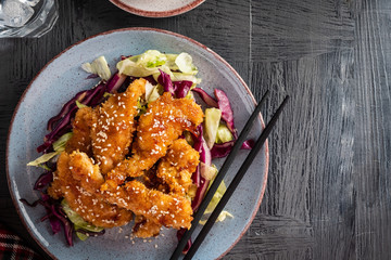 Salad with warm glazing chicken, sprinkled with sesame seeds. Chinese cuisine. Asian culture