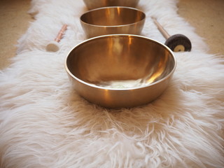 Three singing bowls in a row on a sheepskin for soundhealing, meditation and therapy.