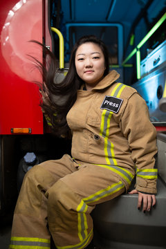 Image of woman firefighter on background of fire truck