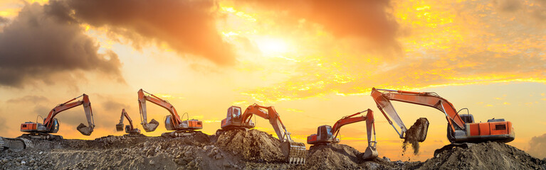 Many excavators work on construction site at sunset,panoramic view
