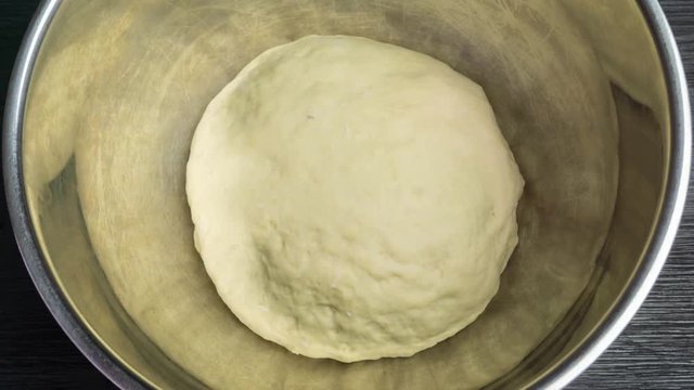 Yeast dough increases in size in a metal bowl