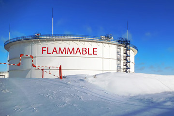Oil tank in winter season. Inscription in English is "flammable".