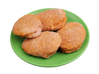 Frozen chicken nuggets with cheese and bacon inside on a green plate isolated