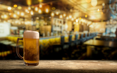 Glass of light beer on a dark pub.