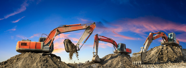 Three excavators work on construction site at sunset,panoramic view © ABCDstock
