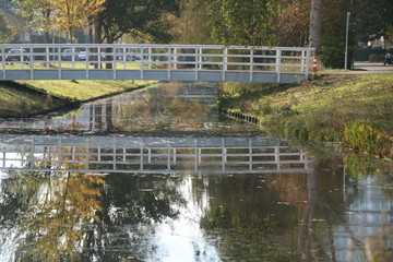 wooden white bridge over ditch in the autumn season in public park Schakenbosch in Leidschendam