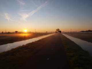 Fototapeta premium Sunrise with morning fog over the meadows of the polder at Goudarak close to Gouda in the Netherlands