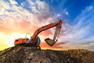 Excavator work on construction site at sunset