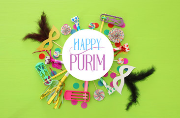 Purim celebration concept (jewish carnival holiday) over green wooden background. Top view.