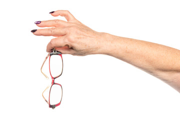Old female hand holds glasses