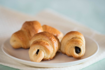 croissant with chocolate on porcelain sauser