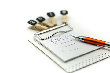 Text 2019 goals on notebook with pen on white background,New year Concept