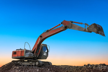 Fototapeta na wymiar Excavator work on construction site at sunset