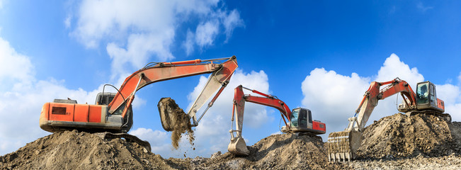 Three excavators working at building site on sunny day © ABCDstock