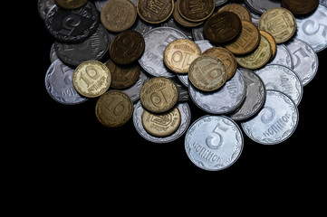 Ukrainian coins isolated on black background. Close-up view. Coins are located above the center of frame. A conceptual image.