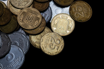 Ukrainian coins isolated on black background. Close-up view. Coins are located at the left side of frame. A conceptual image.