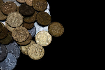 Ukrainian coins isolated on black background. Close-up view. Coins are located at the left side of frame. A conceptual image.