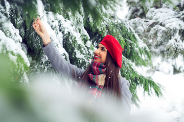 Beautiful woman standing among snowy trees in winter forest - Image