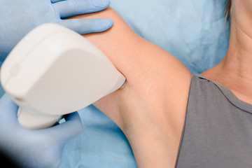 Naklejka premium Closeup of man having underarm laser hair removal treatment in beauty salon