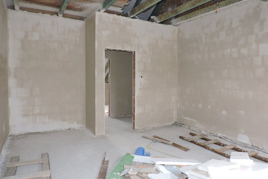 Walls of an empty room under construction covered with hard plaster