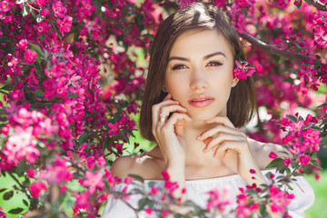 Close up portrait of young beautiful woman with perfect smooth skin. Attractive lady in flowers. Facial portrait of beautiful female.