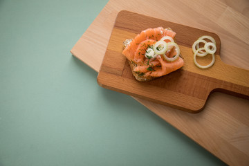Räucherlachs auf Vollkorn Toast Brot mit Zwiebeln, Dill und Meerrettich auf Holzbrett
