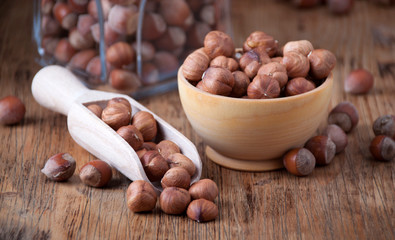 Hazelnuts in a  wooden spoon and wooden bowl