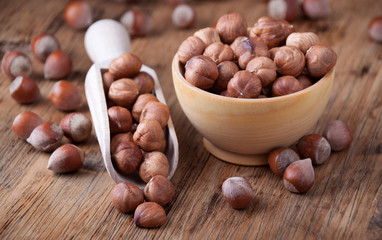 Hazelnuts in a  wooden spoon and wooden bowl