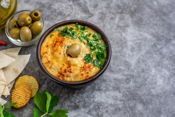 Classic hummus in bowls on a grey background. With copy space
