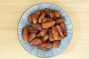 Sweet dried dates fruit in a bowl and on the table