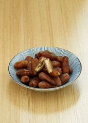 Sweet dried dates fruit in a bowl and on the table