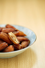 Sweet dried dates fruit in a bowl and on the table
