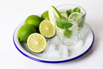 drink, water, mojito lime and mint with ice on a tray on a white background.