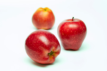 Fototapeta na wymiar three red ripe apples on a white background close-up