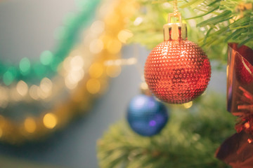 Fototapeta premium Closeup bauble hanging from a decorated Christmas tree on blurred background - Image