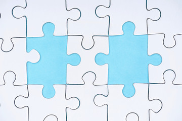 Fototapeta premium flat lay with white puzzle pieces on blue background