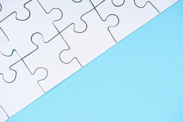 full frame of white puzzles arrangement on blue backdrop