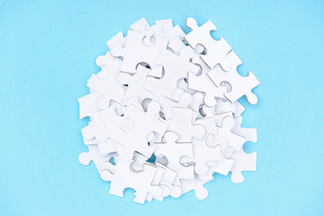 top view of arranged white puzzle elements on blue backdrop
